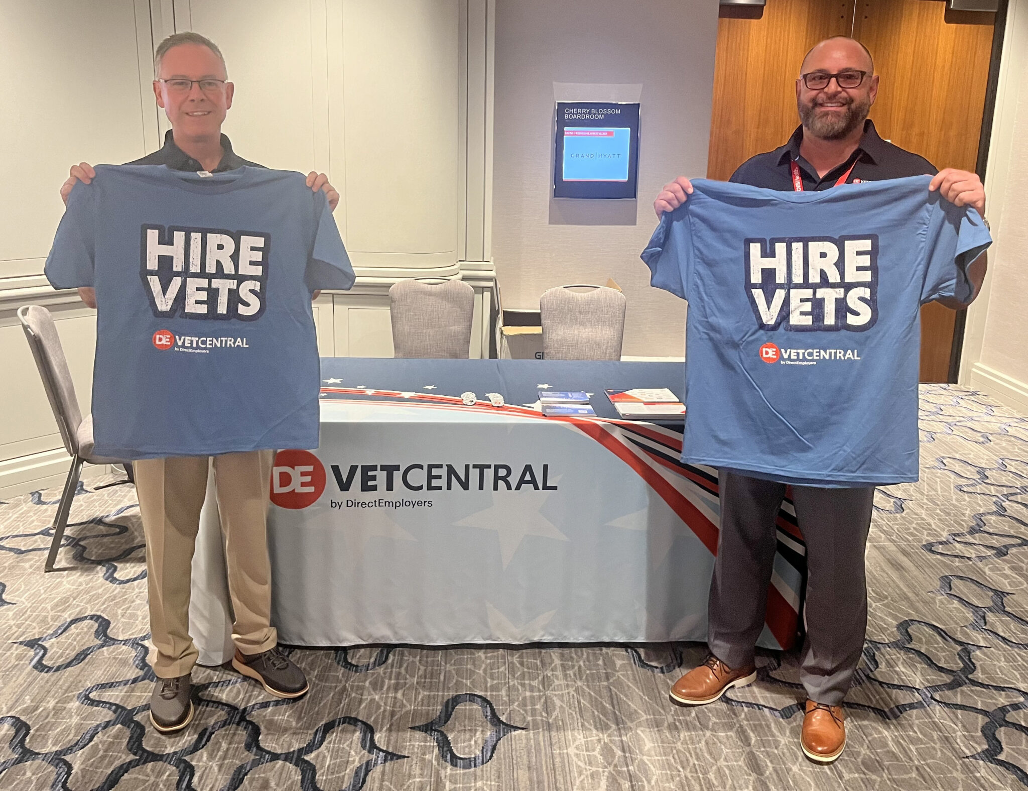 Michael and Ralph holding up Hire Vets t-shirts