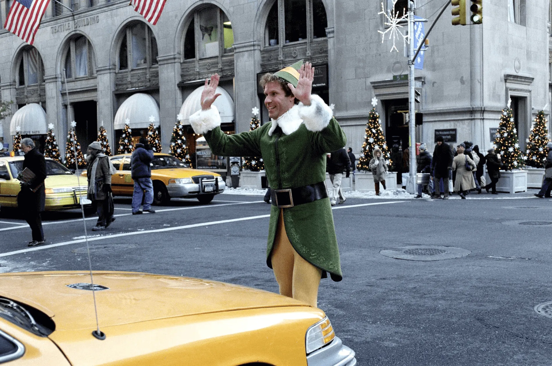 Image of Buddy from the movie Elf, getting stopped by a cab while crossing the street in New York